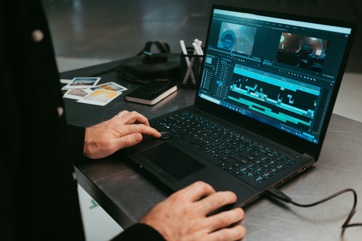 Mani che montano filmati video su un computer portatile.